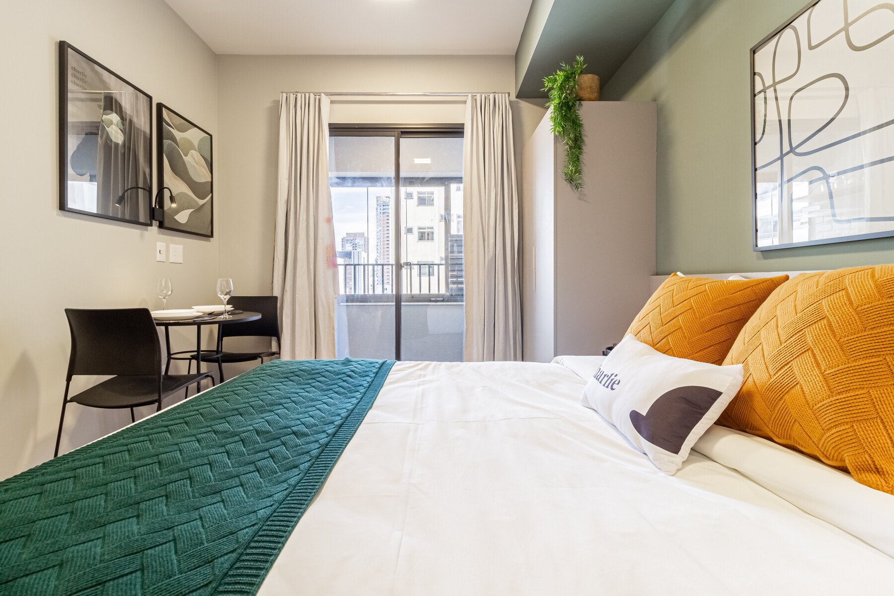 Quarto moderno e aconchegante com decoração contemporânea, camas confortáveis, mesa para refeições e luz natural.