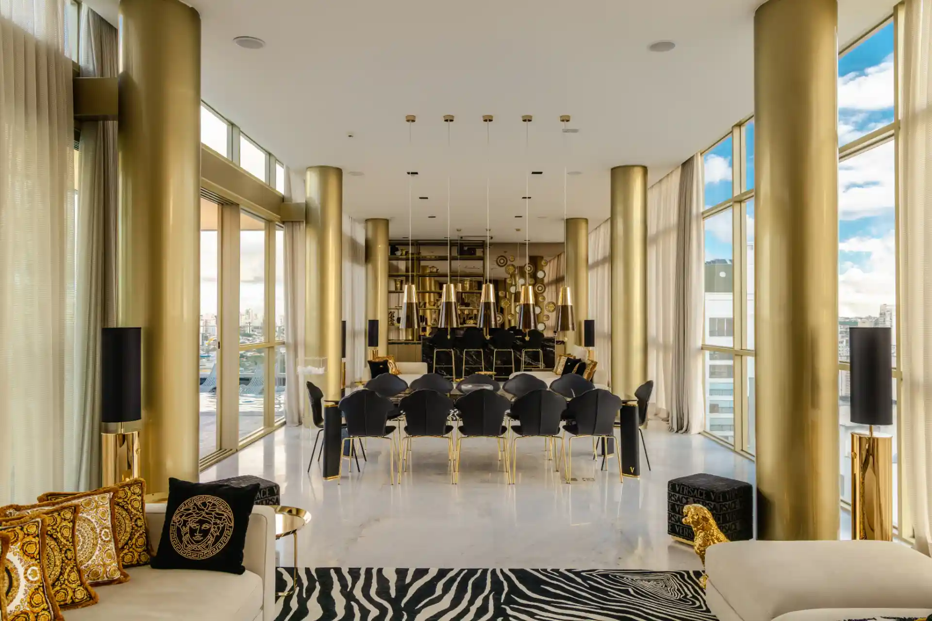 Imagem de um elegante espaço de reuniões com design moderno, grandes janelas de vidro, iluminação de chandeliers dourados e decoração sofisticada